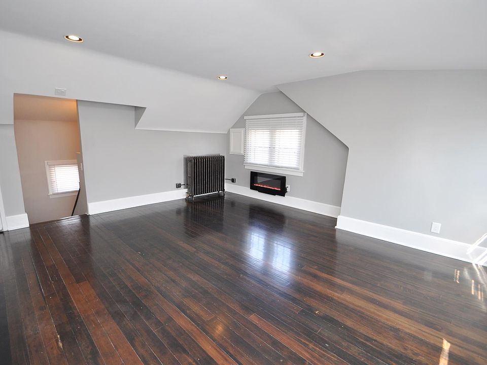 Charming living room with chic electric fireplace, real Douglas Fir hardwood floors, big, bright windows, and dimmable / programmable Philips Hue Smart lighting