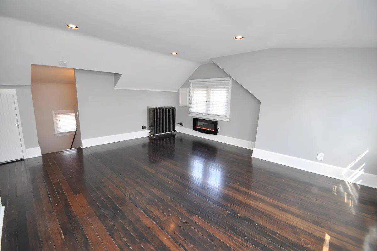 Charming living room with chic electric fireplace, real Douglas Fir hardwood floors, big, bright windows, and dimmable / programmable Philips Hue Smart lighting - 2654 Colfax Ave S #3