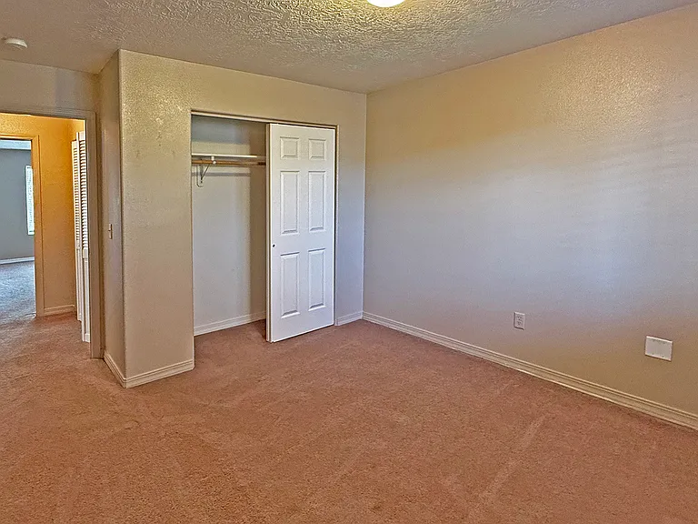 2nd bedroom witth closet and open door overlooking hallway