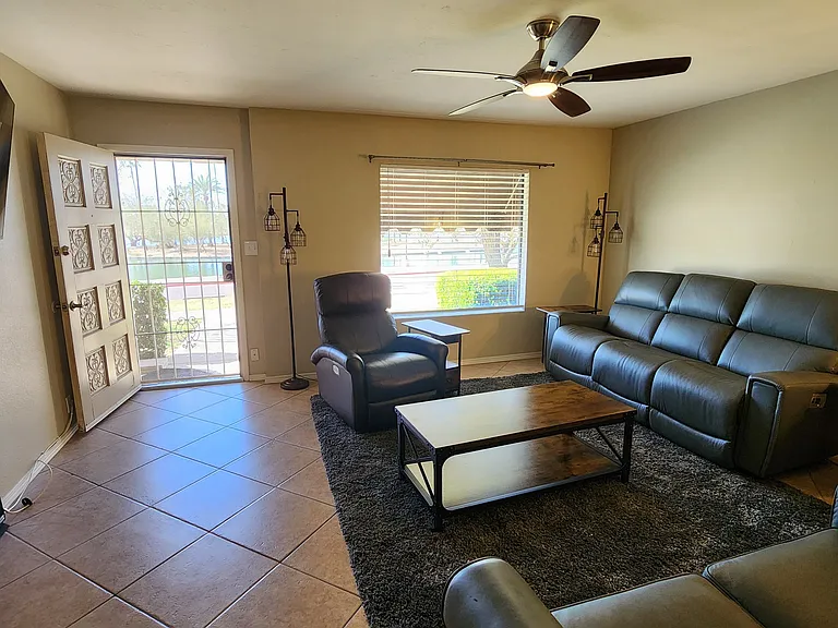 Living room with Lazy-e-boy furniture leads Chaparral park and beautiful lake. Smart Roku TV is mounted on wall to left and easy to view from furniture.