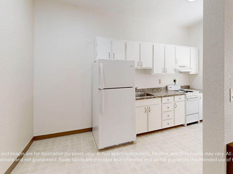 Minimalist kitchen with cabinets and appliances, including a fridge and stove. Neutral color palette with countertops and tiled floor.