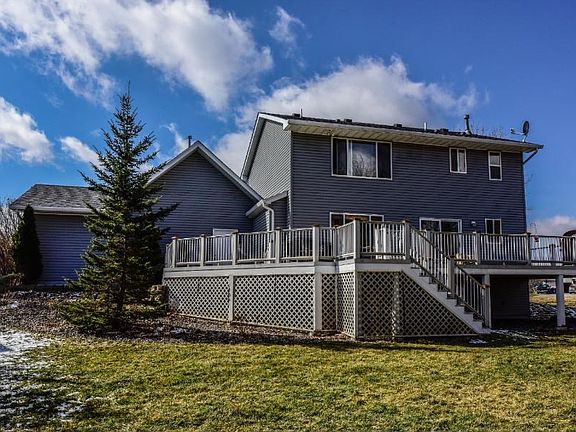 Veiw of back of home highlighting the large deck and yard.