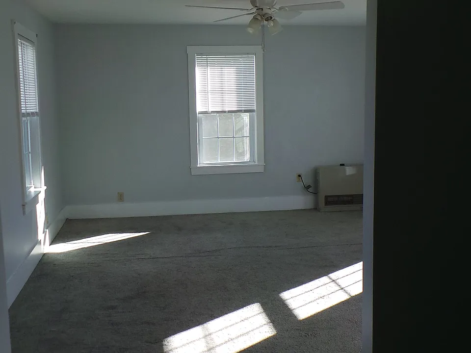 Master bedroom looking straight in. Two windows on the left, two windows on the right, one window straight on. River view of the Kennebec.