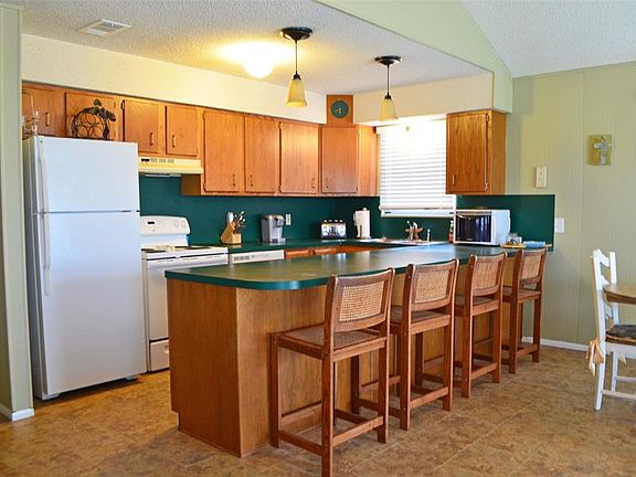 Open galley kitchen with wide counter space & additional seating at the breakfast bar.