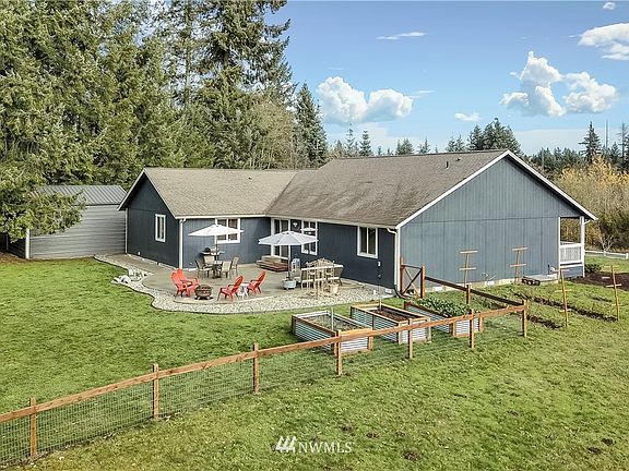 View of rear of home, expanded patio and fenced-in area for your animals and/or gardening, boxes stay! 