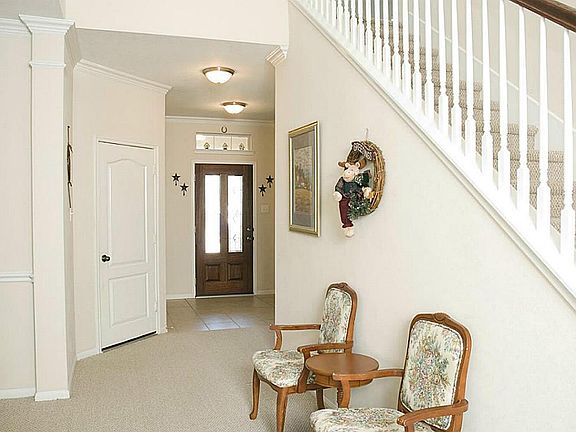 The leaded glass door opens to tile flooring. The glass door and the transom above help add natural light to this space.