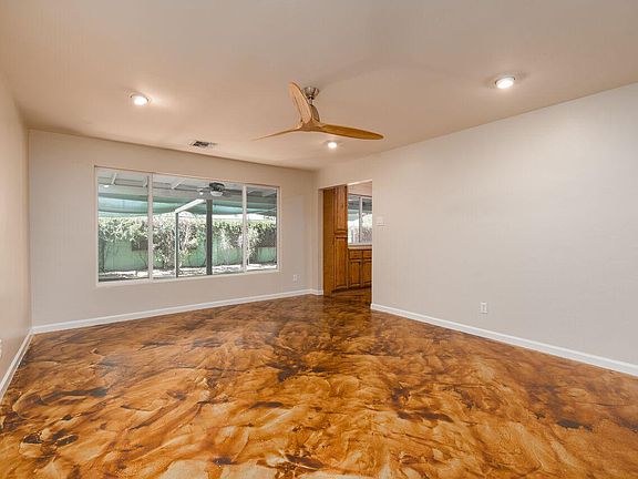 Large living room with picture window and ceiling fan