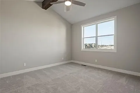 Primary bedroom 1 features a vaulted ceiling with a fan