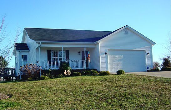 Located hilltop, this home has a rocking-chair porch with mountain views