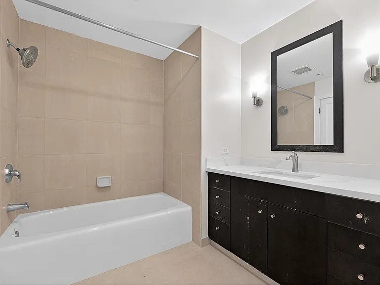 Full bathroom with shower/tub combination, recently regrouted tile, large vanity, updated countertop, and tile flooring.