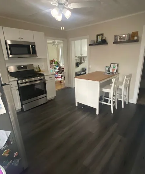 Kitchen. Stainless fridge. GE gas stove. GE microwave. Laminate floor.