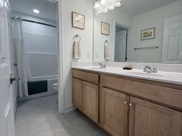 Upstairs hallway bathroom with double sink and separate shower/toilet room.