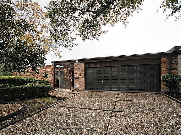 Double-wide Pebblestone Driveway to 2 car garage with separate storeroom.