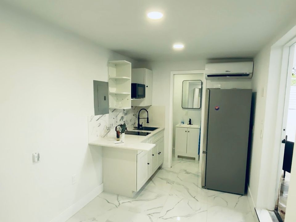 Kitchen equipped with refrigerator, stove, and moicrowave.