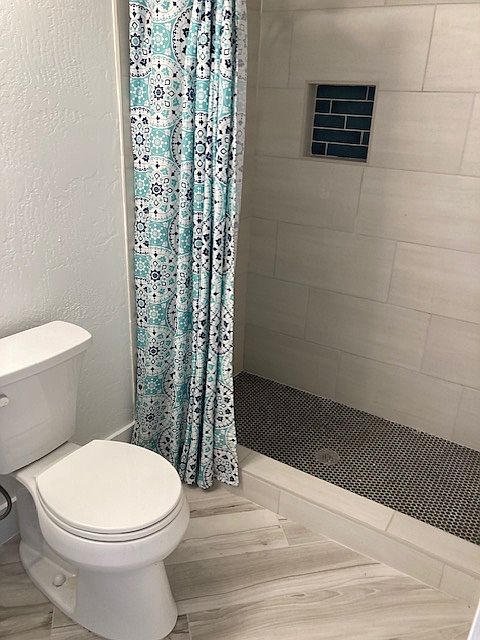 Large tile shower with large granite sink vanity for room to spread out. Once again, new tile flooring, toilet.