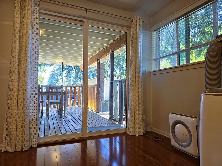 Living connected to the covered deck/patio with relaxing backyard view