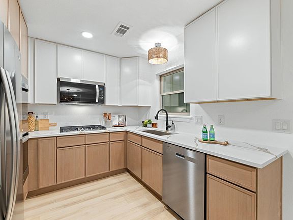 Fully updated kitchen with double ovens, a gas range, and fridge included. Modernized with a sleek appeal.