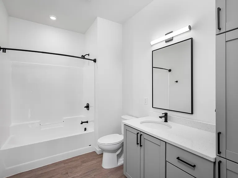 Elegant bathroom with modern fixtures, featuring a sleek white bathtub, chic vanity, and stylish mirror under soft lighting. Elegant bathroom with modern fixtures, featuring a sleek white bathtub, chic vanity, and stylish mirror under soft lighting.