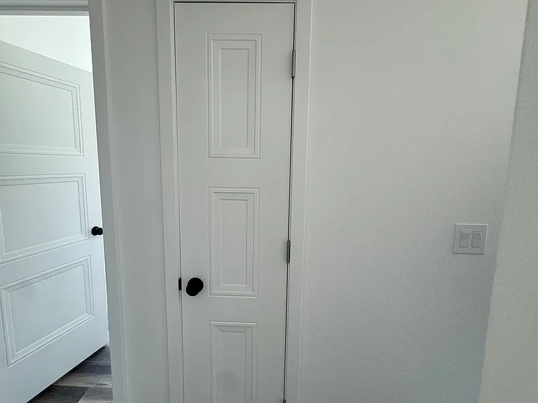 Utility closet is located between kitchen and laundry room. Doorbell is also visible.