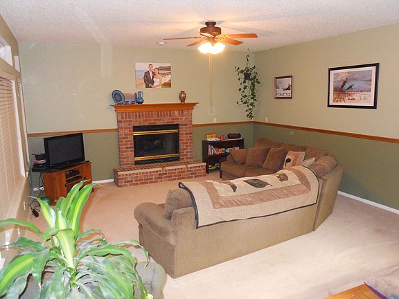 Cozy family room includes a gas fireplace and a ceiling fan