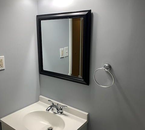 Updated bright bathroom lighting and cabinetry.