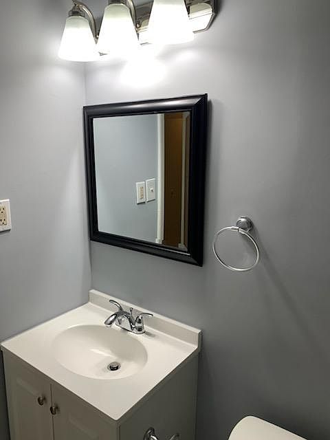 Updated bright bathroom lighting and cabinetry.