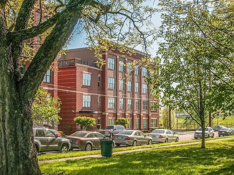 Tree lined park setting in front of the building.
