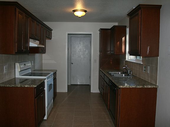 Kitchen with new cabinets, granite couner tops, vent hood, dishwasher and floor