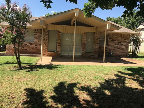 Covered patio at back of house; fenced back yard. 