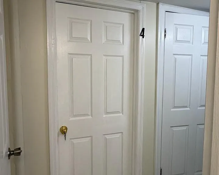 Interior hallway with tiled flooring and multiple doors for access to nearby rooms and storage areas.