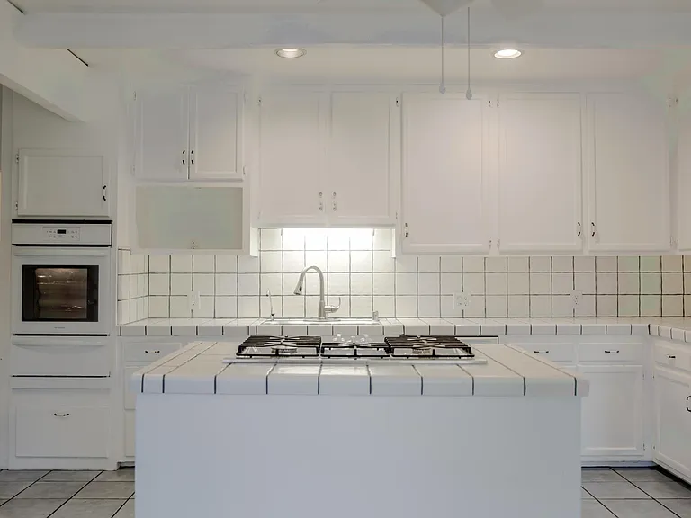 Kitchen island stove with vent that rises up out of the island. Vacuums up all vapors from cooking.