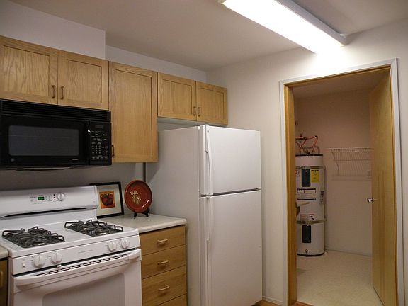 Kitchen w/Gas stove, microwave/vent, refrigerator and doorway to laundry room
