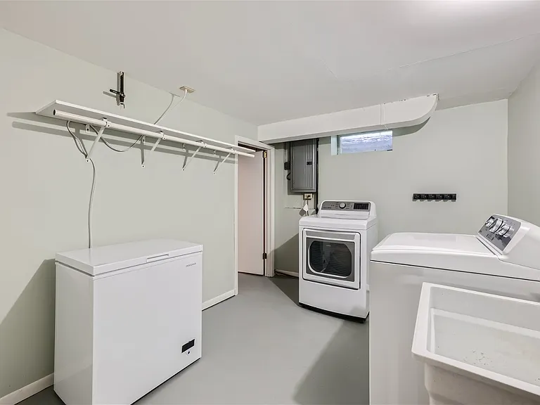 Clean and bright laundry room with chest freezer (if needed) and utility sink