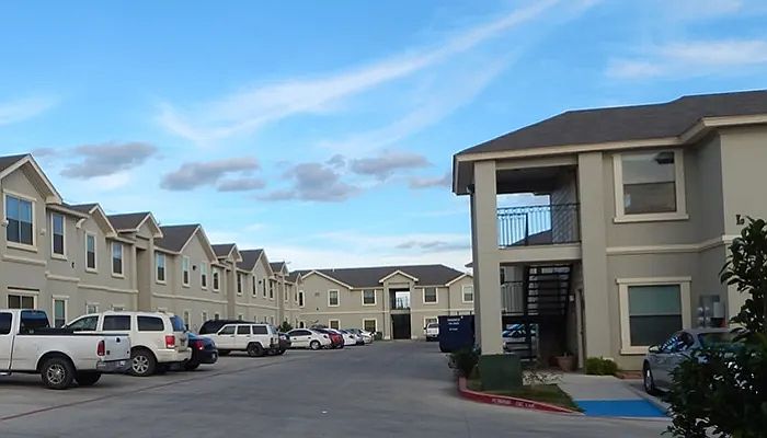 Exterior Apartment Buildings with Parked Cars and Truck Cloudy Skies View - La Joya Apartments in Laredo Texas