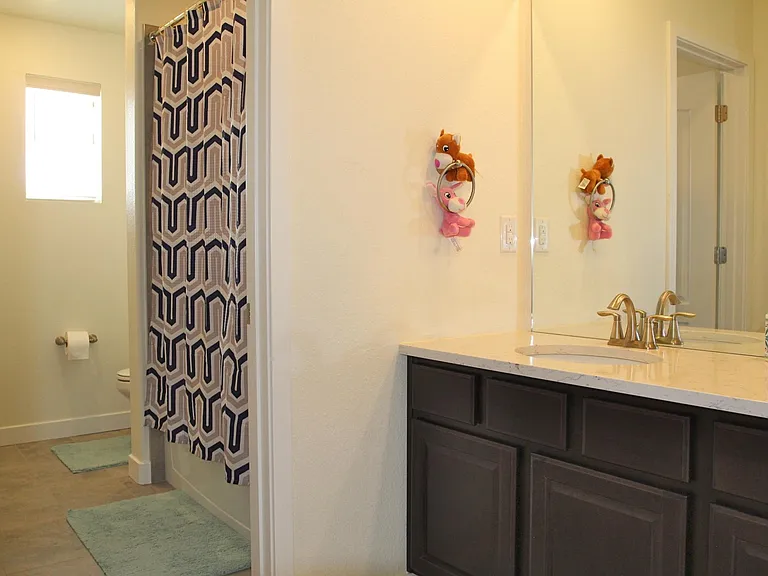 Shared bath has a privacy door separating the tub and toilet from the double vanity