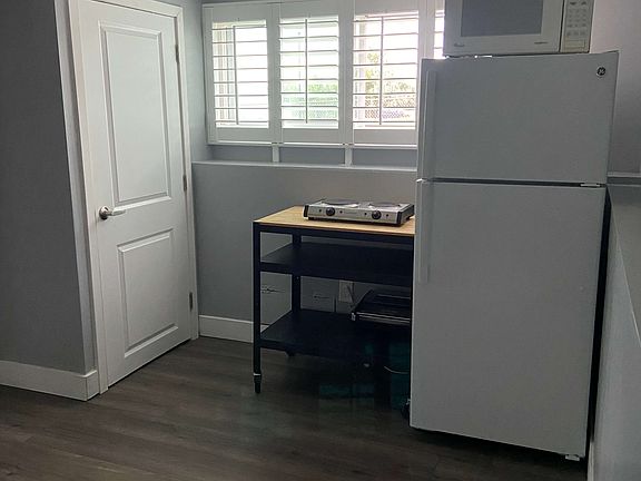 Kitchen area complete with fridge, freezer, microwave, toaster oven, hot plate, and pantry