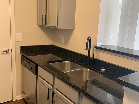 Gray to the ceiling cabinets, granite counter tops, deep double sink, swan neck faucet. Has garbage disposal and dishwasher.