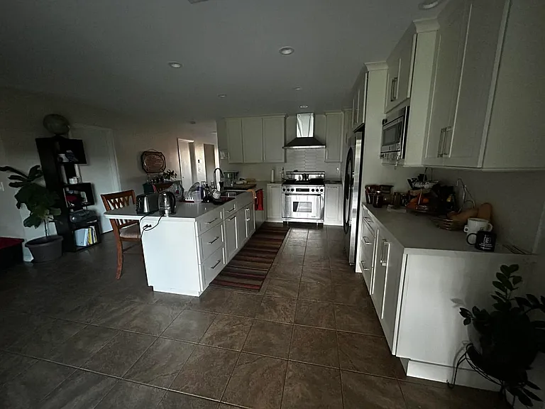 Shared kitchen and dining area/flex space to the left. Leads to the large room available for rent