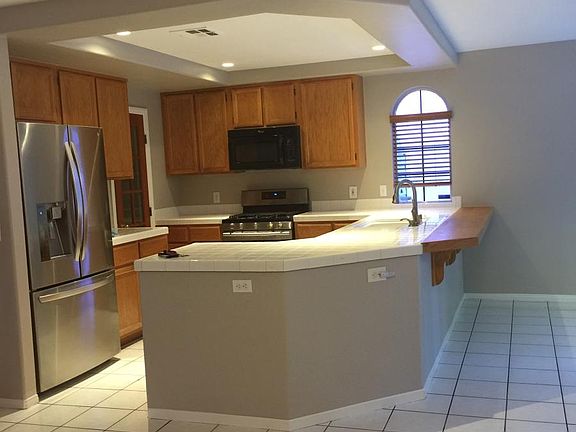 Kitchen, with stainless steel refrigerator, stove, dishwasher, and walk-in pantry. Breakfast bar to family room.