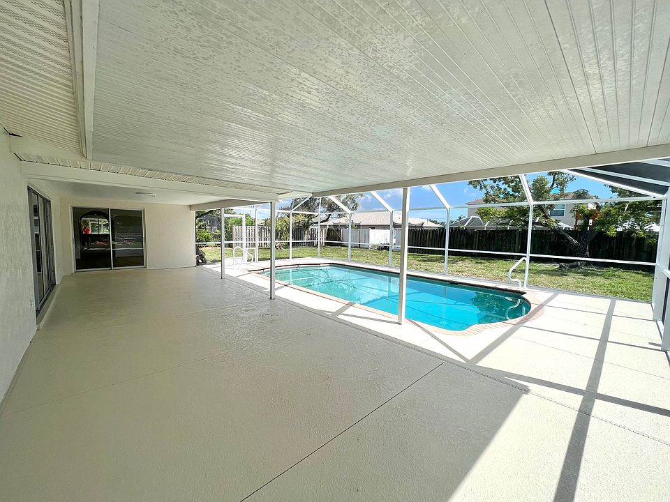 Very large covered lanai with caged pool and fenced back yard.