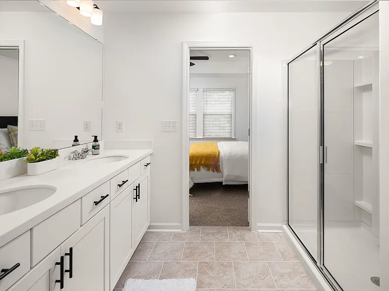 Elegant primary bath featuring a double vanity and walk-in shower.