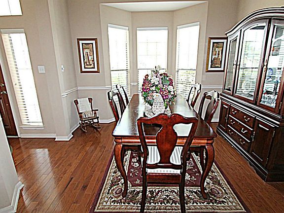 THIS FORMAL DINING ROOM FEATURES CHAIR RAILING & A BAY WINDOW