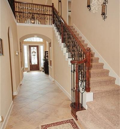 Two story entry with wrought iron staircase.