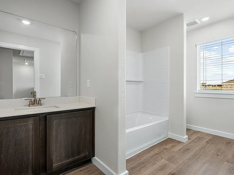 The secondary bathroom has a vanity space and a shower-tub combo.