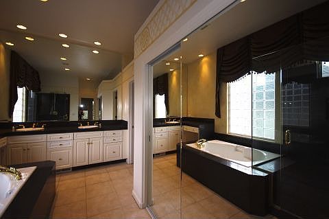 Master Bathroom has mirrored closet doors &amp; tile floors.