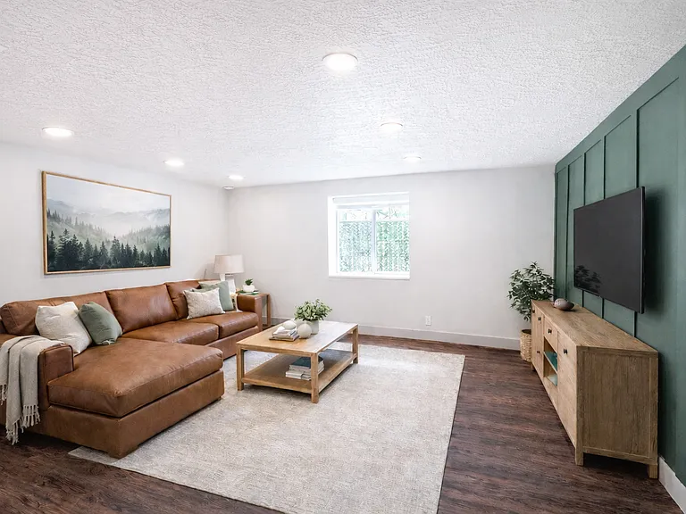 Bright and spacious living area with modern finishes and accent wall.