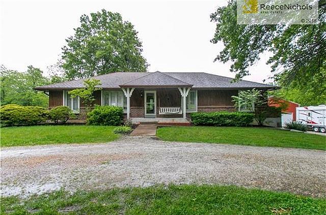 Front view of house w/circle drive and front porch.