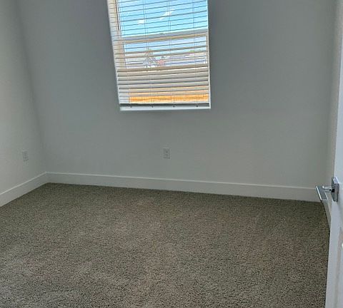 Bedroom with plush new carpet and natural light.