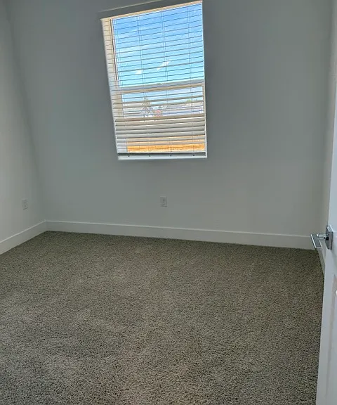 Bedroom with plush new carpet and natural light.