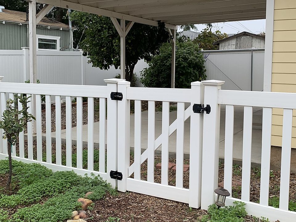 Entrance to fenced yard from main property. Perimeter privacy fencing between neighbors and alley